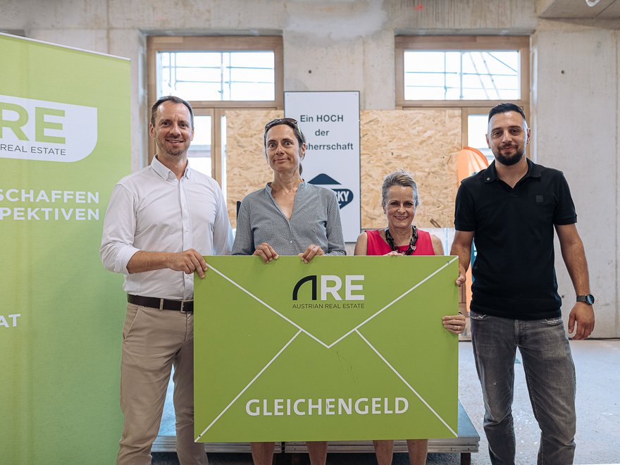 Dachgleiche ANCHOR - ARE Projektteam Andreas Untersperger und Ulrike Hahn übergeben gemeinsam mit Christine Dornaus das Gleichengeld an Polier Leutrim Shala