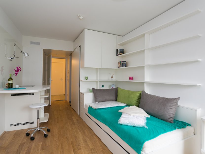 Zimmer mit weißen Möbeln und bunter Dekoration
